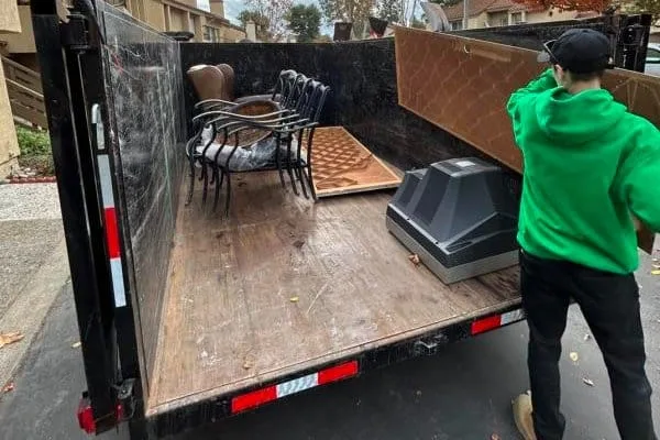 a man standing in the back of a truck with furniture