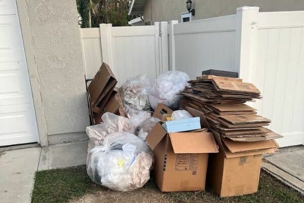 a pile of boxes and boxes in front of a white fence