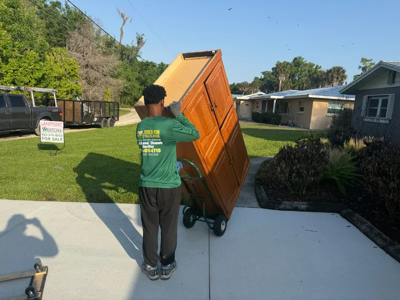 Junk removal in Lake Wales FL — Dibs On Your Junk crew loading furniture from a residential property